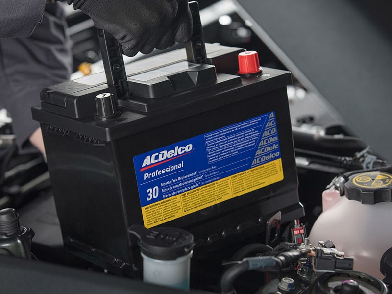 Mechanic inspecting a car brake disc with a tool, wearing gloves, highlighting automotive maintenance.