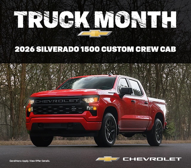 Red 2026 Chevrolet Silverado 1500 Custom Crew Cab on a road, promoting Truck Month.