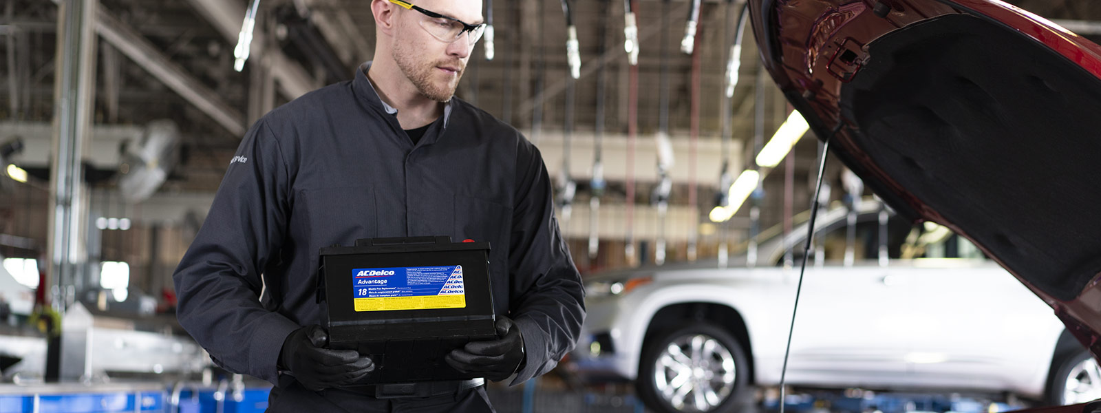 A technician holding a genuine ACDelco battery