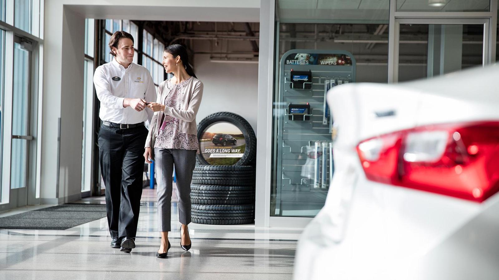 A service advisor handing keys back to a customer at the service desk