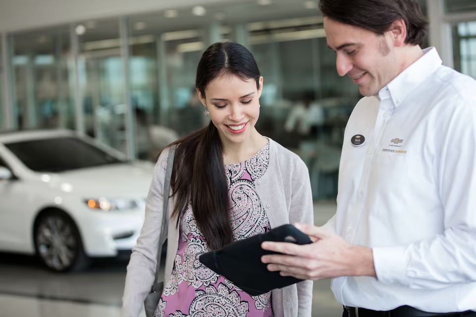 A service advisor going through details on a tablet with a customer