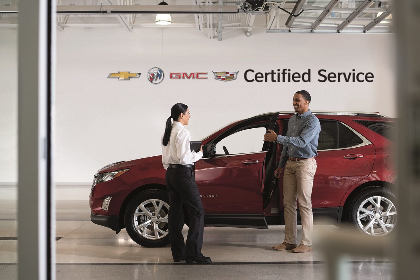 A customer and an advisor beside a Chevrolet Equinox with the driver's door open