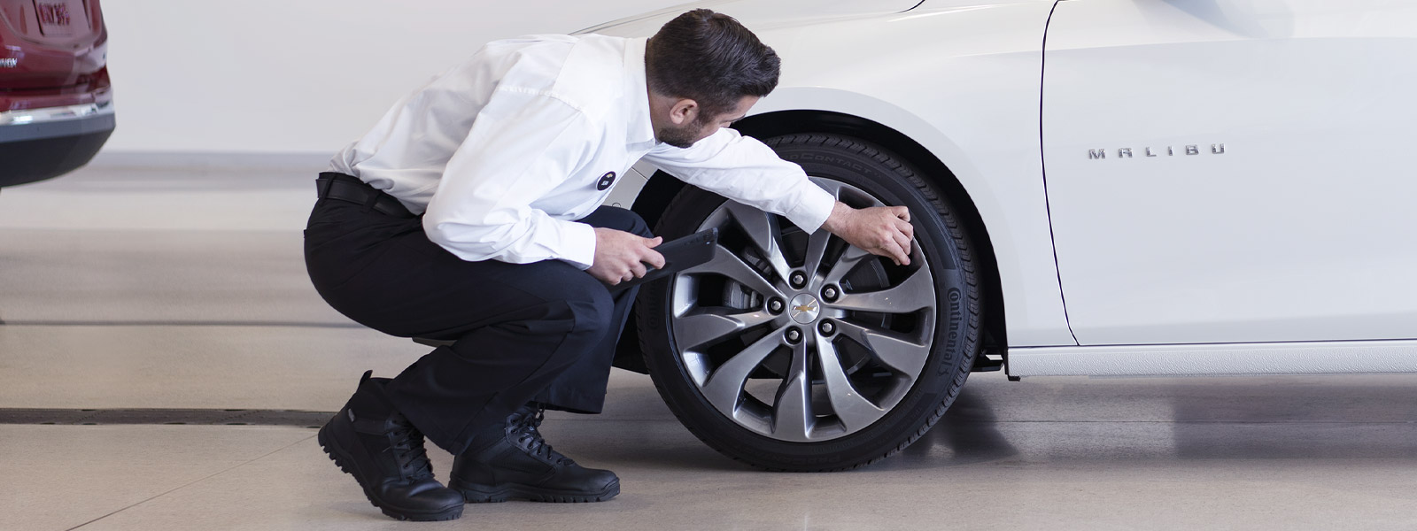 An RMP Chevrolet advisor inspecting a tire