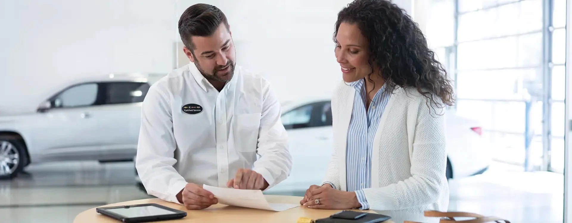 A finance advisor going through paperwork with a customer at the desk