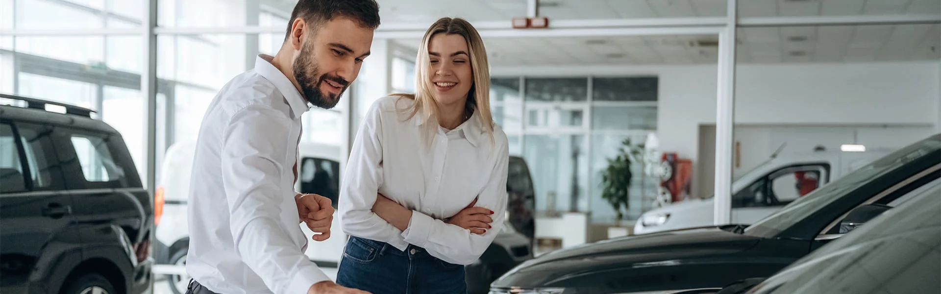 A sales consultant and a customer looking over a vehicle on the showroom floor at RMP Chevrolet in Regina